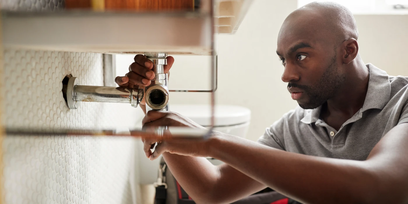 a male plumber fixing a pipe connection from Dallas TX Plumbing in Dallas, TX - Plumber near me
